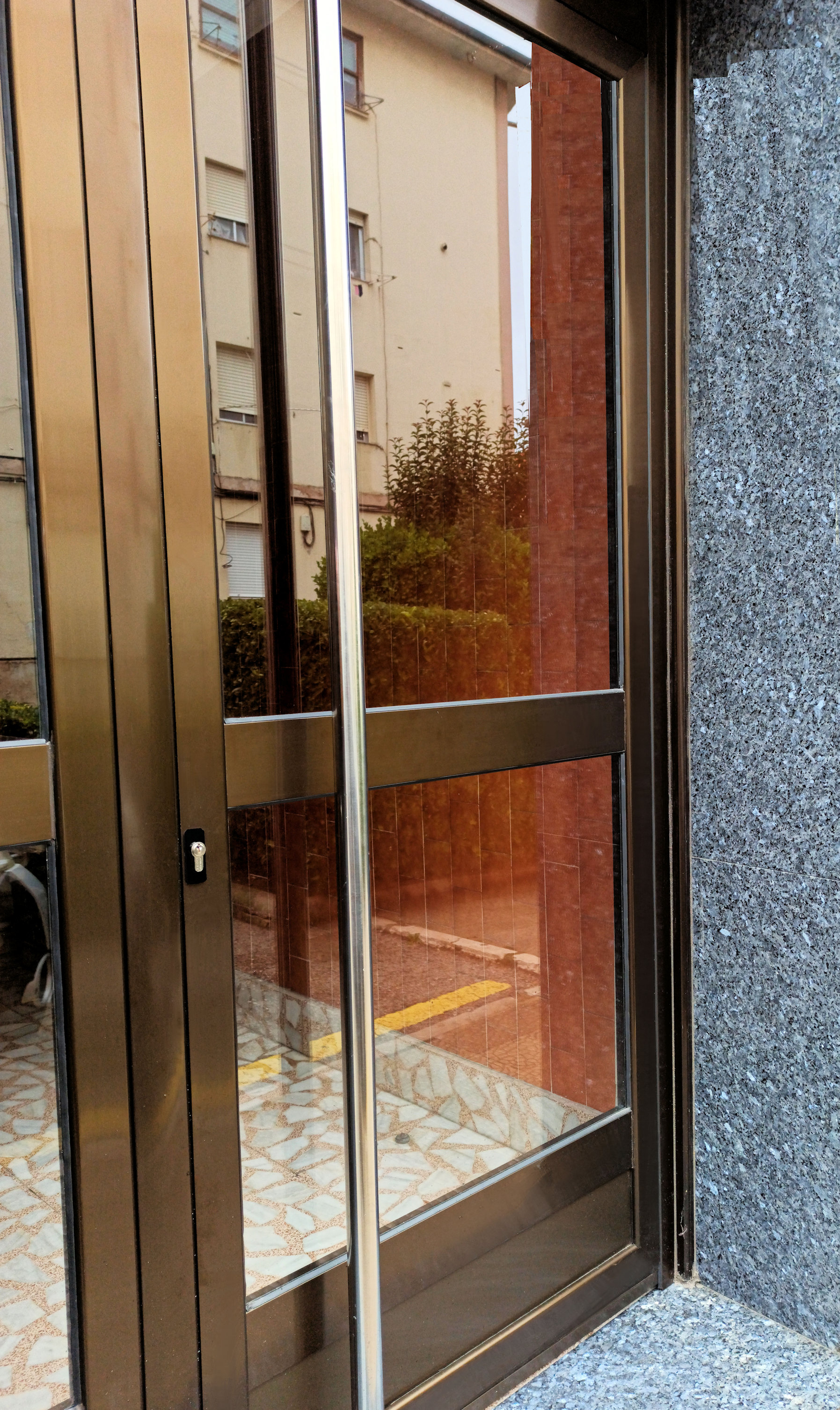 puerta de portal en aluminio anodizado en bronce en Santander