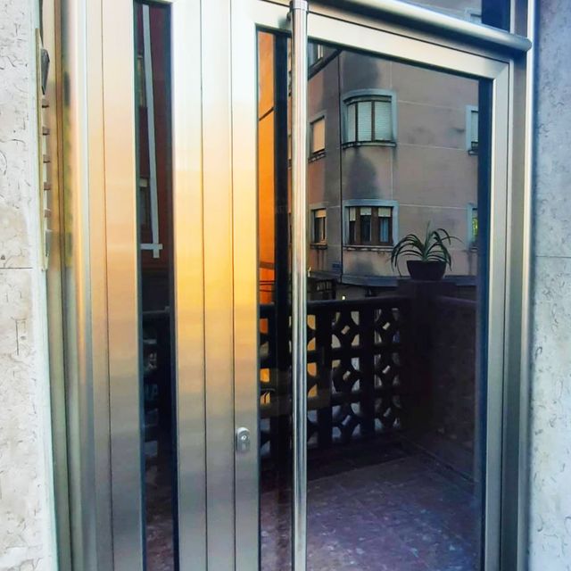 Puerta de portal en imitación inoxidable en Cantabria. VENTANAS DE LA PARTE